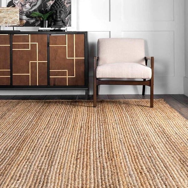 Stylish living room with a natural jute rug, mid-century armchair, and geometric wooden sideboard.