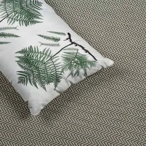 Fern-patterned-cushion-on-a-brown-herringbone-carpet.